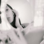 beautiful woman looking at reflection in mirror