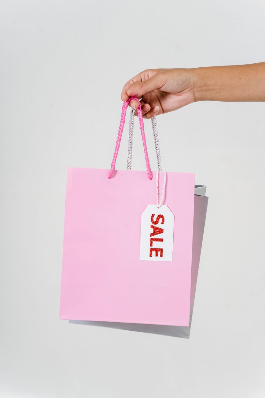 a person holding pink shopping bag