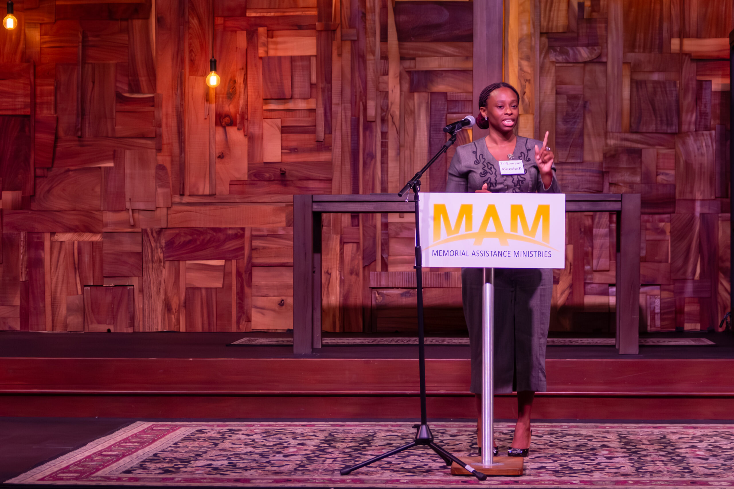 Ta'Quaryan on stage holding her graduation certificate with another graduate at the MAM Innova program